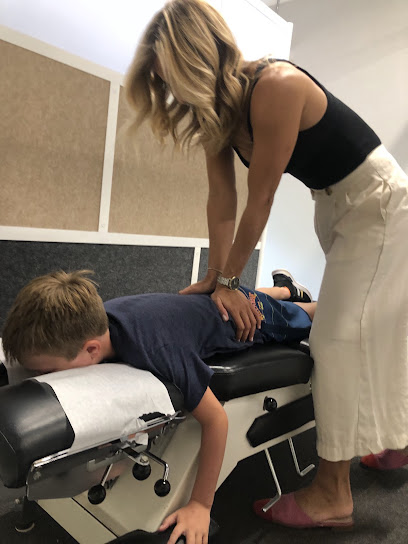Chiropractor providing hands-on care to a young patient on an adjustment table