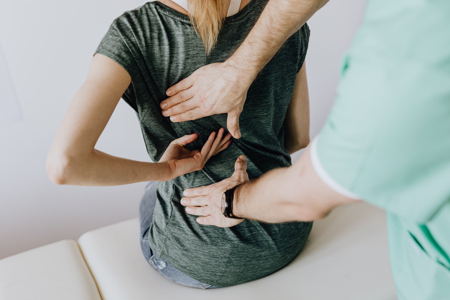 Practitioner assessing a patient back during a clinic visit